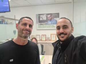 יהודה כהן יועץ משכנתאות עם לקוח מחייך בסניף בנק לאחר סגירת משכנתא